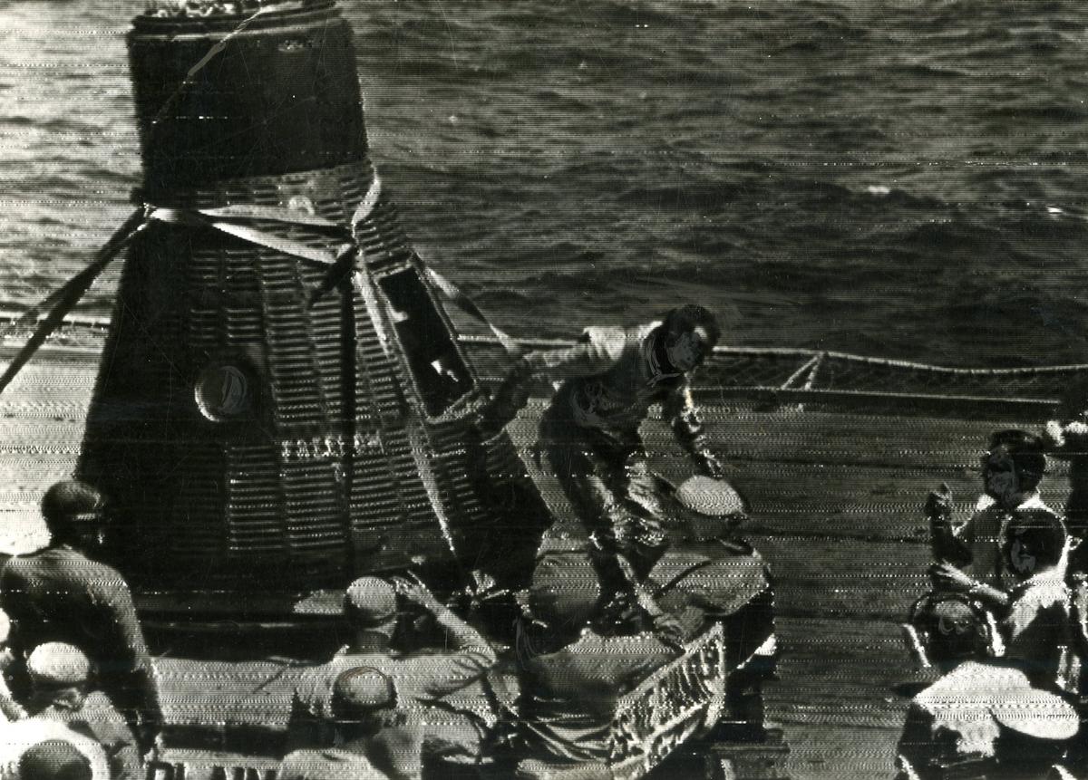 آلن شپرد هنگام خروج از کپسول در ناو هواپیمابر USS Lake Champlain در 5 می 1961 کلاه فضایی خود را در دست دارد.